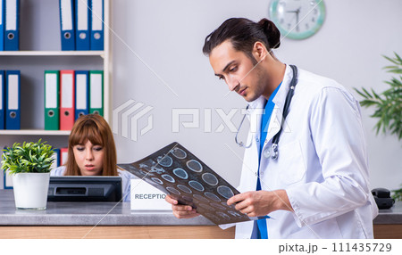 Two doctors working at the reception in the hospital Two doctors working at the reception in the hospital 111435729