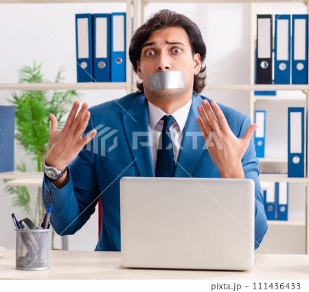 Young male employee with tape on the mouth Young male employee with tape on the mouth 111436433