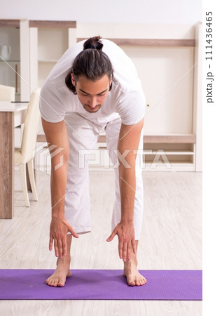 Young man doing physical exercises at home 111436465