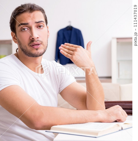 Young male student preparing for exams at home Young male student preparing for exams at home 111437019
