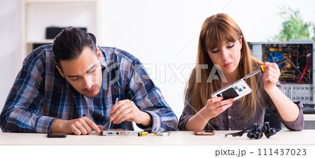 Two technicians working at computer warranty center Two technicians working at computer warranty center 111437023