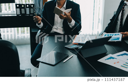 Business team meeting working with new startup project, discussion and analysis data the charts and graphs. Digital tablet, calculator, laptop computer using, Business finance and accounting concept. 111437187