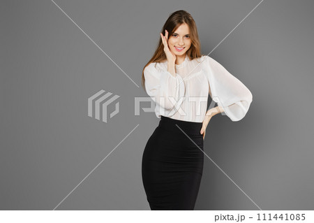 Playful young woman in pencil skirt and blouse 111441085
