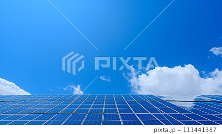 Solar panels on the green field with blue sky and white clouds. Conceptual image of environmental protection. 111441387