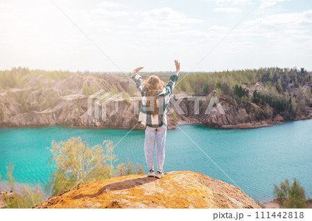 Young girl on the top of mounting and feeling free and looking at the blue lake 111442818