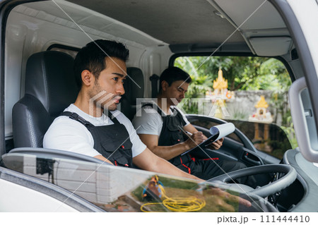 Mover workers driving truck for moving and transportation service. Teamwork in delivering furniture. Ethnicity diversity among smiling employees. House moving service concept. Mover workers driving truck for moving and transportation service. Teamwork in delivering furniture. Ethnicity diversity among smiling employees. House moving service concept. 111444410