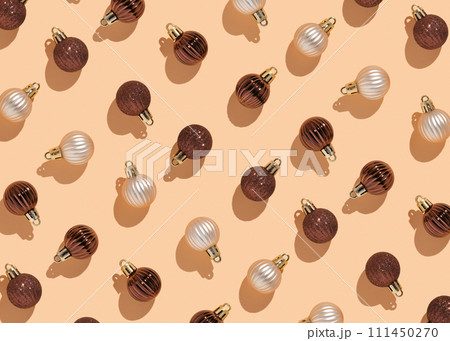 pattern of glittery Christmas balls in cream and chocolate colors on a beige background pattern of glittery Christmas balls in cream and chocolate colors on a beige background 111450270