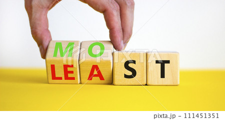 Most or least symbol. Businessman turns beautiful wooden cubes and changes the word Least to Most. Beautiful yellow table white background. Copy space. Business and most or least concept. Most or least symbol. Businessman turns beautiful wooden cubes and changes the word Least to Most. Beautiful yellow table white background. Copy space. Business and most or least concept. 111451351