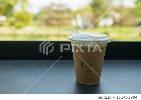 Ice cappuccino coffee on table with spring garden view of outdoor cafe 111451904