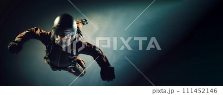 man in special uniform jumps with parachute, soars in air against background of sky, clouds. 111452146