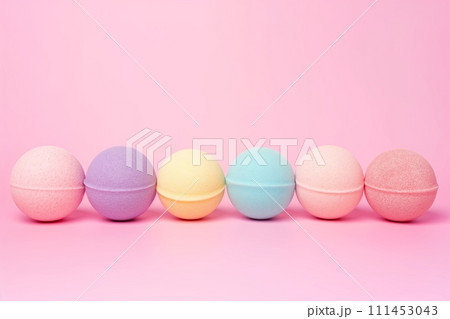 A variety of multicolored bath bombs balls on a pink background with space for text 111453043