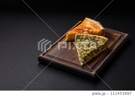 Delicious crispy quiche cut into slices with cheese, broccoli, tomatoes 111453997