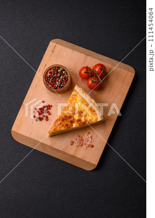 Delicious crispy quiche cut into slices with cheese, broccoli, tomatoes 111454064