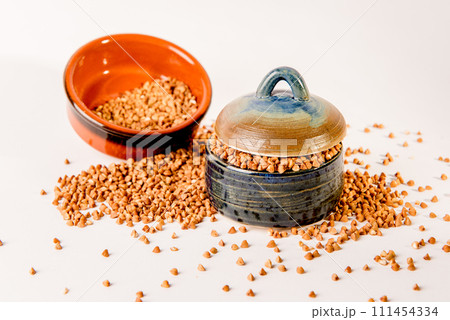 Bowl with raw uncooked buckwheat, Raw Buckwheat Pile, Dry Buck Wheat Grains, Uncooked Buckwheat 111454334