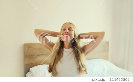 Healthy sleep, relaxed middle aged woman wakes up on the bed at home 111455803