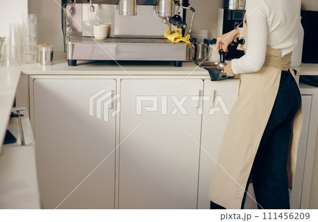 Close-up of barista making coffee with manual presses using tamper at the coffee shop Close-up of barista making coffee with manual presses using tamper at the coffee shop 111456209