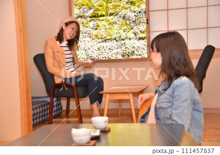 女子旅で宿泊する宿の部屋で話をする若い二人の女性 女子旅で宿泊する宿の部屋で話をする若い二人の女性 111457837