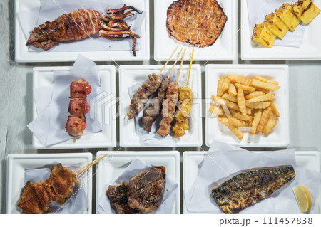 Grilled meat on skewers with french fries on a white plate Grilled meat on skewers with french fries on a white plate 111457838