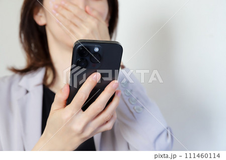 スマホを見て驚く女性 111460114