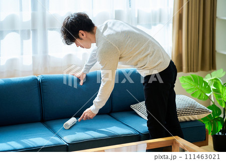 ソファーの掃除をする若い男性 ソファーの掃除をする若い男性 111463021