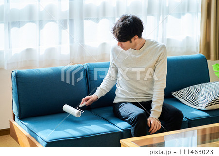 ソファーの掃除をする若い男性 111463023