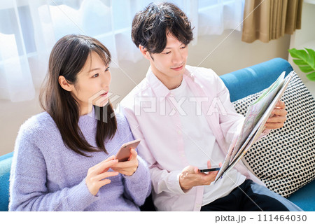 地図とスマートフォンを持って話す男女 地図とスマートフォンを持って話す男女 111464030