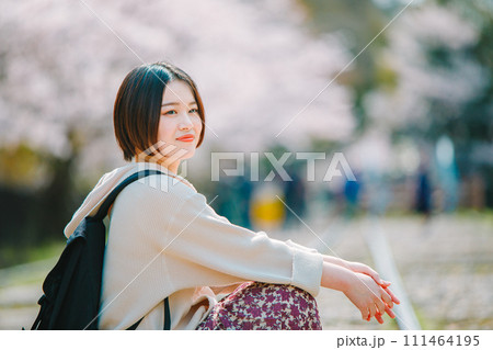 春の京都観光でインクラインの線路に座る女性 111464195