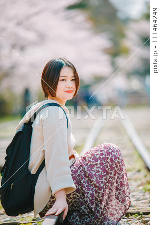 春の京都観光でインクラインの線路に座る女性 111464249