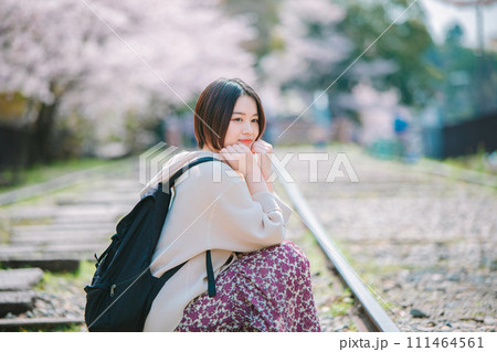 春の京都観光でインクラインの線路に座る女性 111464561