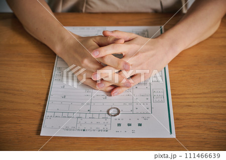 離婚届の上に結婚指輪を置く女性 離婚届の上に結婚指輪を置く女性 111466639