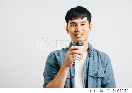 Portrait of a smiling Thai teenager, holding a coffee cup. Studio shot isolated on white background with copy space. His joyful expression is pure happiness. 111467559