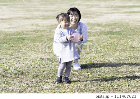 公園の芝生広場で遊ぶ園児と保育士 111467623