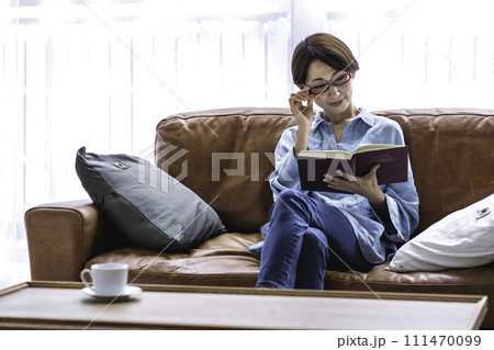 ソファーで読書をするミドルの女性 111470099