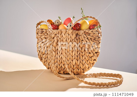 Easter colored eggs in a wicker bag. Easter composition. Easter colored eggs in a wicker bag. Easter composition. 111471049