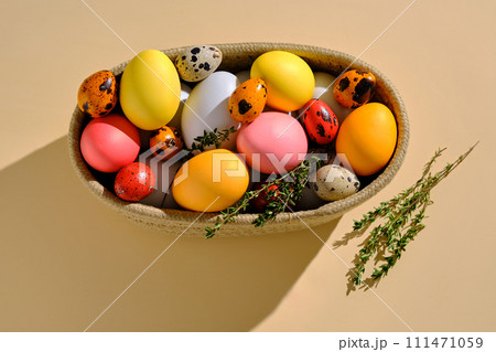 Easter colored eggs in a wicker basket. Easter composition. Easter colored eggs in a wicker basket. Easter composition. 111471059