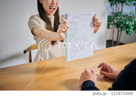 離婚届を夫に突きつける30代女性 離婚届を夫に突きつける30代女性 111471089
