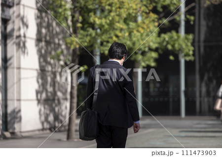 オフィス街を歩く中年サラリーマンの後ろ姿 111473903