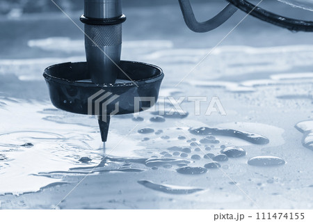 The abrasive waterjet cutting machine cutting the metal plate in the light blue scene. The abrasive waterjet cutting machine cutting the metal plate in the light blue scene. 111474155