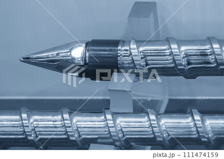 Close up scene the head of barrel screw of injection machine spare parts in the light blue scene. Close up scene the head of barrel screw of injection machine spare parts in the light blue scene. 111474159