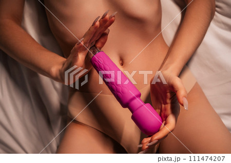 pink sex vibrator in hands of a naked woman... - Stock Photo [111474207]
