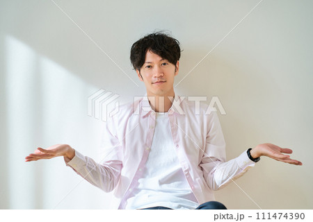 2つの選択肢を比較するようなポーズをする若い男性 2つの選択肢を比較するようなポーズをする若い男性 111474390