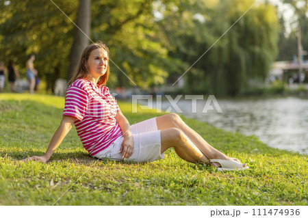 Relaxed Woman Sitting by the Lake Relaxed Woman Sitting by the Lake 111474936