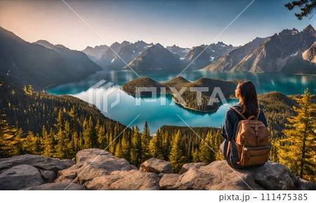 Backpack-adorned girl standing at edge of serene mountain lake 111475385