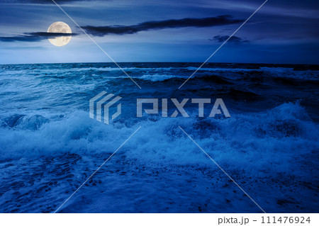 dramatic seascape at night. waves crashing on the beach in full moon light dramatic seascape at night. waves crashing on the beach in full moon light 111476924