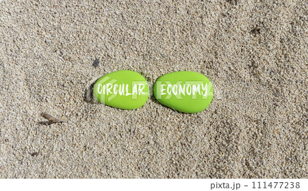 Circular economy symbol. Concept words Circular economy on beautiful green stone. Beautiful sand beach background. Business circular economy concept. Copy space. 111477238