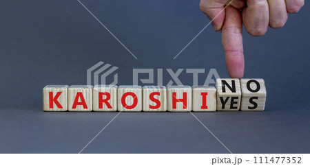 Karoshi yes or no symbol. Concept words Karoshi Yes or No on beautiful wooden blocks. Beautiful grey table grey background. Businessman hand. Business and stop karoshi concept. Copy space. 111477352