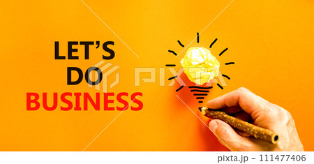 let is do business symbol. Concept words let is do business on beautiful orange paper. Beautiful orange background. Light bulb icon. Businessman hand. let is do business concept. Copy space. let is do business symbol. Concept words let is do business on beautiful orange paper. Beautiful orange background. Light bulb icon. Businessman hand. let is do business concept. Copy space. 111477406