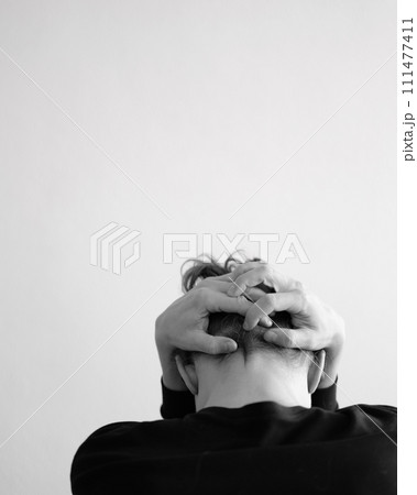 Portrait of a person holding their head in a pose of contemplation or distress Portrait of a person holding their head in a pose of contemplation or distress 111477411