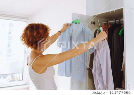 Teenager girl looking at clothes in wardrobe Teenager girl looking at clothes in wardrobe 111477666