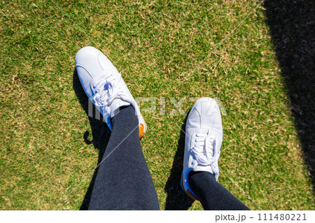 爽やかな青空のゴルフ場・ティーイングエリアに立つタイツの女性の足元（神奈川県湯河原町） 111480221